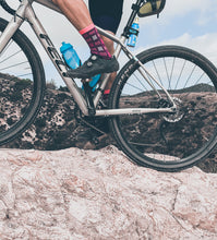 Load image into Gallery viewer, Riding over rock in the Purpel cycling sock